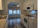 This bright kitchen offers an eat-in area, white cabinets and appliances, and wood-look vinyl floors at 1610 Reynolds Rd # 211, Lakeland, FL 33801