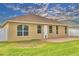 Backyard view of home showcasing neutral paint, brick patio, and green grass at 3226 Oak Tree Ln, Winter Haven, FL 33884