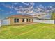 Large backyard featuring a brick patio, green grass, and a white vinyl fence at 3226 Oak Tree Ln, Winter Haven, FL 33884