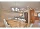 Bright dining room features a large wooden table, white chairs, and pendant lighting at 3226 Oak Tree Ln, Winter Haven, FL 33884