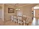 Traditional dining room with white chairs, tiled flooring, chandelier, and a wall art piece at 3226 Oak Tree Ln, Winter Haven, FL 33884