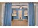 Flex room with blue walls, ceiling fan, and sliding door with curtains at 3226 Oak Tree Ln, Winter Haven, FL 33884