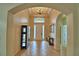Inviting foyer with tile floors, arched doorways and a tray ceiling with modern chandelier at 3226 Oak Tree Ln, Winter Haven, FL 33884