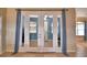 Double french doors with blue curtains leading to a room with natural light at 3226 Oak Tree Ln, Winter Haven, FL 33884