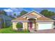 Charming front exterior featuring a well-manicured lawn, brick driveway, and attached garage at 3226 Oak Tree Ln, Winter Haven, FL 33884