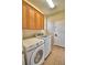 Laundry room with tile floor, overhead storage, modern washer and dryer with door and sink at 3226 Oak Tree Ln, Winter Haven, FL 33884