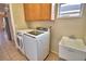 Well-organized laundry area featuring overhead cabinets, modern appliances, and a convenient utility sink at 3226 Oak Tree Ln, Winter Haven, FL 33884