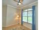 Bright living room featuring a ceiling fan, tan walls and a large window with blue curtains at 3226 Oak Tree Ln, Winter Haven, FL 33884