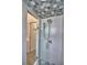 Updated shower with white subway tile, glass door, and decorative ceiling tile at 3226 Oak Tree Ln, Winter Haven, FL 33884