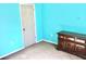 Bedroom with teal walls, wood dresser, and carpet flooring at 3709 Feather Dr, Lakeland, FL 33812