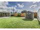 A spacious backyard featuring a shed, green grass, and a screened-in patio area, perfect for outdoor enjoyment at 4617 S Devon Ave, Lakeland, FL 33813