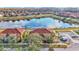 Aerial view of a townhouse community near a lake with lush green surroundings at 531 Las Fuentes Dr, Kissimmee, FL 34746