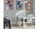 Bright dining area with white table set and unique Disney-themed artwork on brick wall at 531 Las Fuentes Dr, Kissimmee, FL 34746