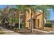 Inviting two-story townhome with a red tiled roof, surrounded by palm trees and lush landscaping at 531 Las Fuentes Dr, Kissimmee, FL 34746