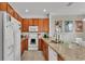 Kitchen with granite countertops, wooden cabinets, and white appliances at 531 Las Fuentes Dr, Kissimmee, FL 34746