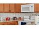 Well-equipped kitchen features warm wood cabinets, granite counters, and modern white appliances at 531 Las Fuentes Dr, Kissimmee, FL 34746