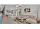 Open living room with sectional sofa, coffee table, and Mickey Mouse art at 531 Las Fuentes Dr, Kissimmee, FL 34746