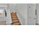 View of the stairs with wood steps, white risers, and white railing at 531 Las Fuentes Dr, Kissimmee, FL 34746