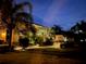 A lovely home and entryway illuminated at dusk with mature trees at 535 Narrow Pond Rd, Polk City, FL 33868
