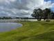A tranquil water view with a clear blue sky and vibrant green grass at 535 Narrow Pond Rd, Polk City, FL 33868