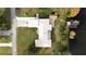 Aerial view showing a home's roof, lawn, driveway, and adjacent waterfront at 6029 Avocado Dr, Indian Lake Estates, FL 33855