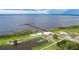 Scenic aerial view of a lakefront park with a long pier extending into the water at 6029 Avocado Dr, Indian Lake Estates, FL 33855