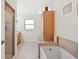 Bright bathroom boasts a separate shower, tub, and built-in linen cabinet for storage at 6029 Avocado Dr, Indian Lake Estates, FL 33855