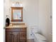 Cozy bathroom featuring wood vanity with granite countertop and warm, inviting lighting at 6029 Avocado Dr, Indian Lake Estates, FL 33855