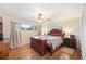 Comfortable bedroom with a ceiling fan, hardwood floors, dresser, and ample natural light from two windows at 6029 Avocado Dr, Indian Lake Estates, FL 33855
