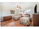 Charming bedroom features hardwood floors, rattan furniture, and plenty of natural light at 6029 Avocado Dr, Indian Lake Estates, FL 33855