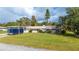 Charming single-story home featuring a spacious front yard and attached carport at 6029 Avocado Dr, Indian Lake Estates, FL 33855