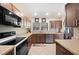 Well-lit kitchen with stainless steel appliances, wood cabinets and a view of the back yard at 6029 Avocado Dr, Indian Lake Estates, FL 33855