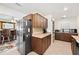Bright kitchen featuring stainless steel appliances, wood cabinets, and a breakfast bar overlooking living area at 6029 Avocado Dr, Indian Lake Estates, FL 33855