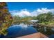 Scenic water view featuring a covered boat dock, lush greenery, and a serene and tranquil setting at 6029 Avocado Dr, Indian Lake Estates, FL 33855