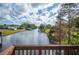 Scenic view of the canal with lush greenery and neighboring homes along the banks, captured from a wooden railing at 6029 Avocado Dr, Indian Lake Estates, FL 33855