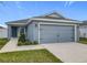 Charming single-story home with gray stucco, well-maintained lawn, and an attached two-car garage at 1354 Mezzavalle Way, Auburndale, FL 33823