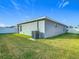 The backyard features a well-maintained lawn and modern air conditioning unit at 1354 Mezzavalle Way, Auburndale, FL 33823
