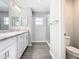 Clean bathroom with double sinks, granite countertops, and a walk-in shower at 1354 Mezzavalle Way, Auburndale, FL 33823