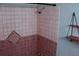 Shower with decorative tile and a red and beige color scheme at 1305 Avenue S Nw, Winter Haven, FL 33881