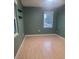 Light-filled bedroom with green walls and laminate wood floors at 1305 Avenue S Nw, Winter Haven, FL 33881