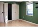 Bedroom with green walls, wood floors, and a chalkboard accent wall at 1305 Avenue S Nw, Winter Haven, FL 33881