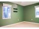 Light-filled bedroom with green walls and laminate wood floors at 1305 Avenue S Nw, Winter Haven, FL 33881