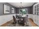 Elegant dining room with a round glass table, modern chandelier, and wainscoting details at 1305 Avenue S Nw, Winter Haven, FL 33881