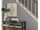 Close-up entryway featuring tile floors, stairs, decorative table with books and art, and gray walls at 1305 Avenue S Nw, Winter Haven, FL 33881