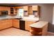 L-shaped kitchen with wood cabinets and tile counters at 1305 Avenue S Nw, Winter Haven, FL 33881