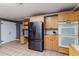 Open kitchen featuring tile floors, wooden cabinets, black appliances, and plenty of storage at 1305 Avenue S Nw, Winter Haven, FL 33881