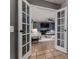View through French doors into a living room with modern furnishings and decor, including a fireplace and TV at 1305 Avenue S Nw, Winter Haven, FL 33881