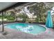 Enclosed pool area with in-ground pool with dolphin tiles, hot tub, waterfall, and screen enclosure with covered seating at 1305 Avenue S Nw, Winter Haven, FL 33881