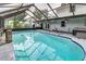 Enclosed pool area with in-ground pool with dolphin tiles, hot tub, waterfall, and screen enclosure with covered seating at 1305 Avenue S Nw, Winter Haven, FL 33881