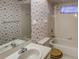 Bathroom with tub, shower, and seashell wallpaper at 3940 Laurel Branch Dr, Lakeland, FL 33810